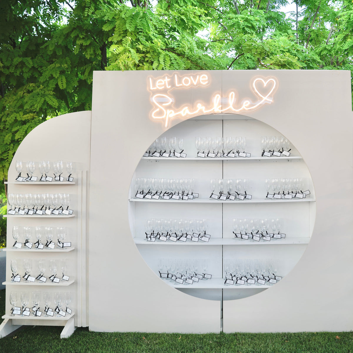 Decorative wall with 'Let Love Sparkle' sign and shelves outdoors