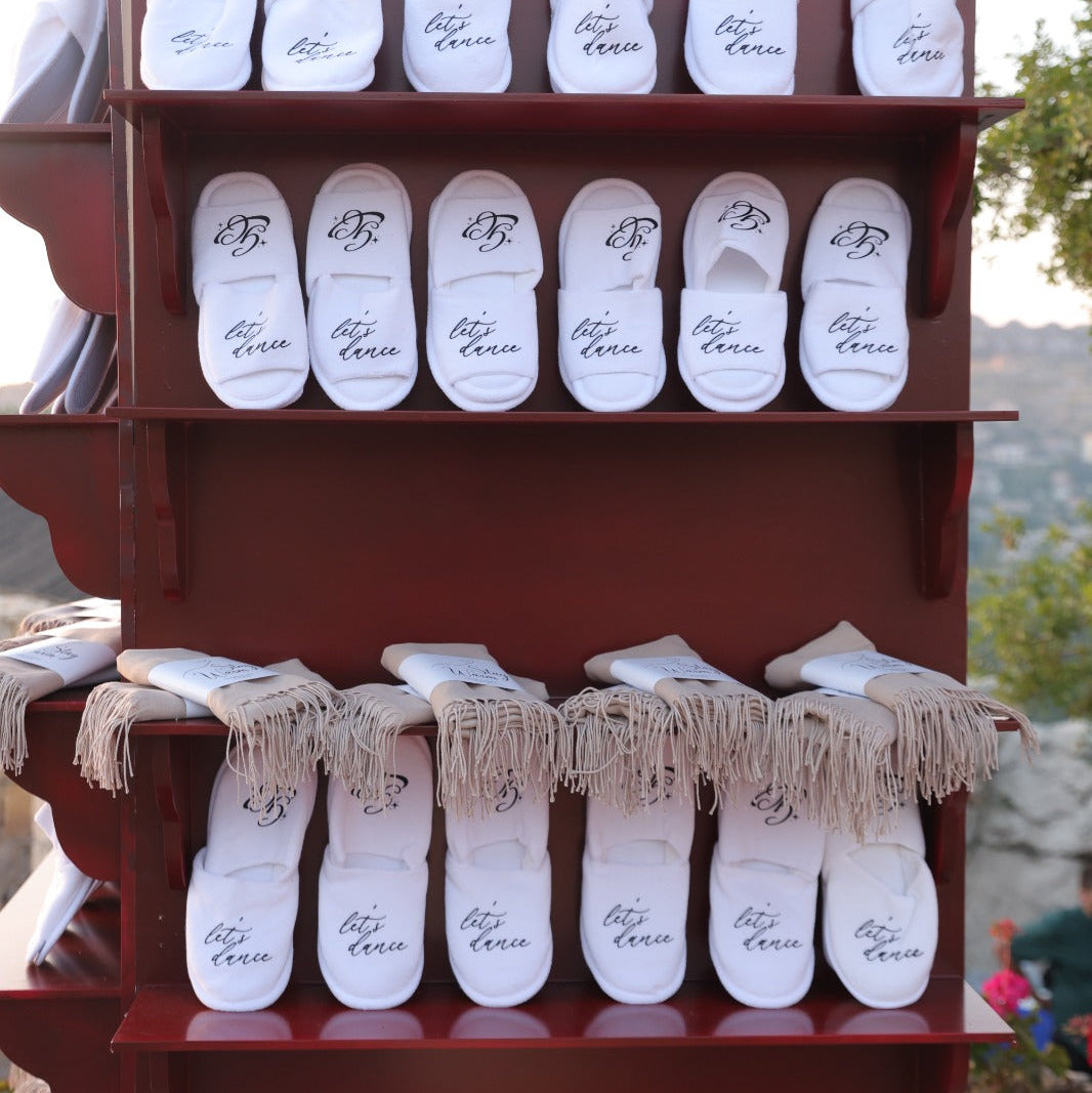 Display of white giveaways with branding on a red rack against a natural background.