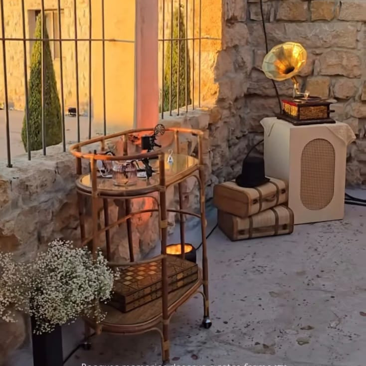 Outdoor setting with a stone wall, metal bar cart, and decorative elements.