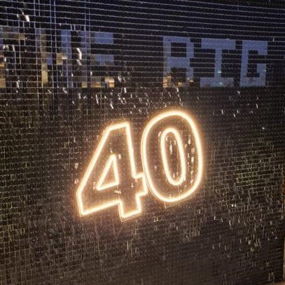 Neon '40' sign on a textured wall with 'THE BIG' text above it.