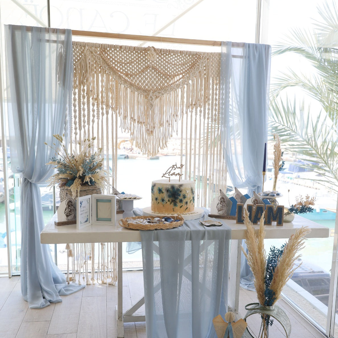 Decorative setup with a table, flowers, and decorative elements in a bright room.