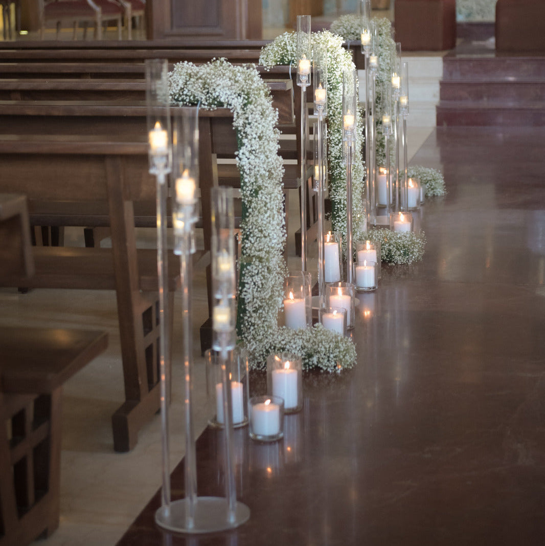 Decorative setup with candles and floral arches in a church setting