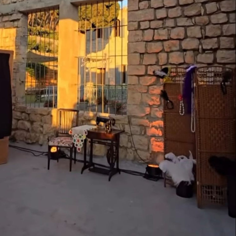 Stone-walled outdoor area with furniture and decor, including a table and chairs.