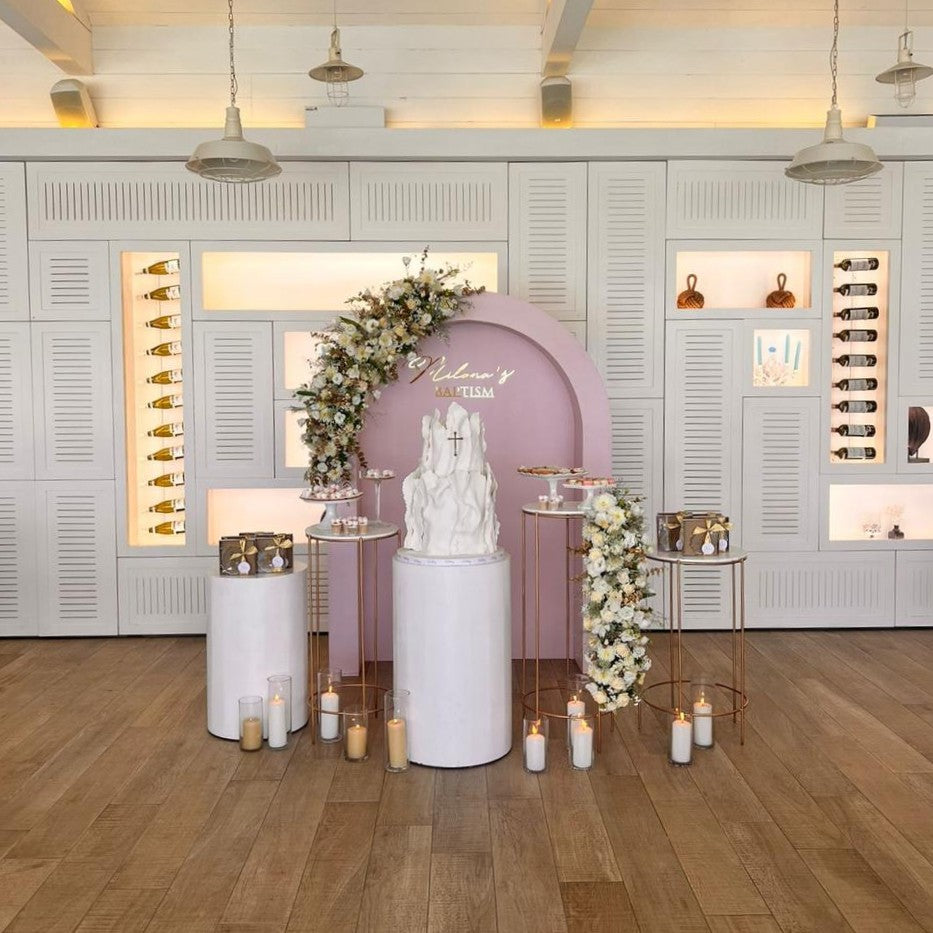 Decorative setup with a cake, flowers, and candles for a baptism or holy communion.