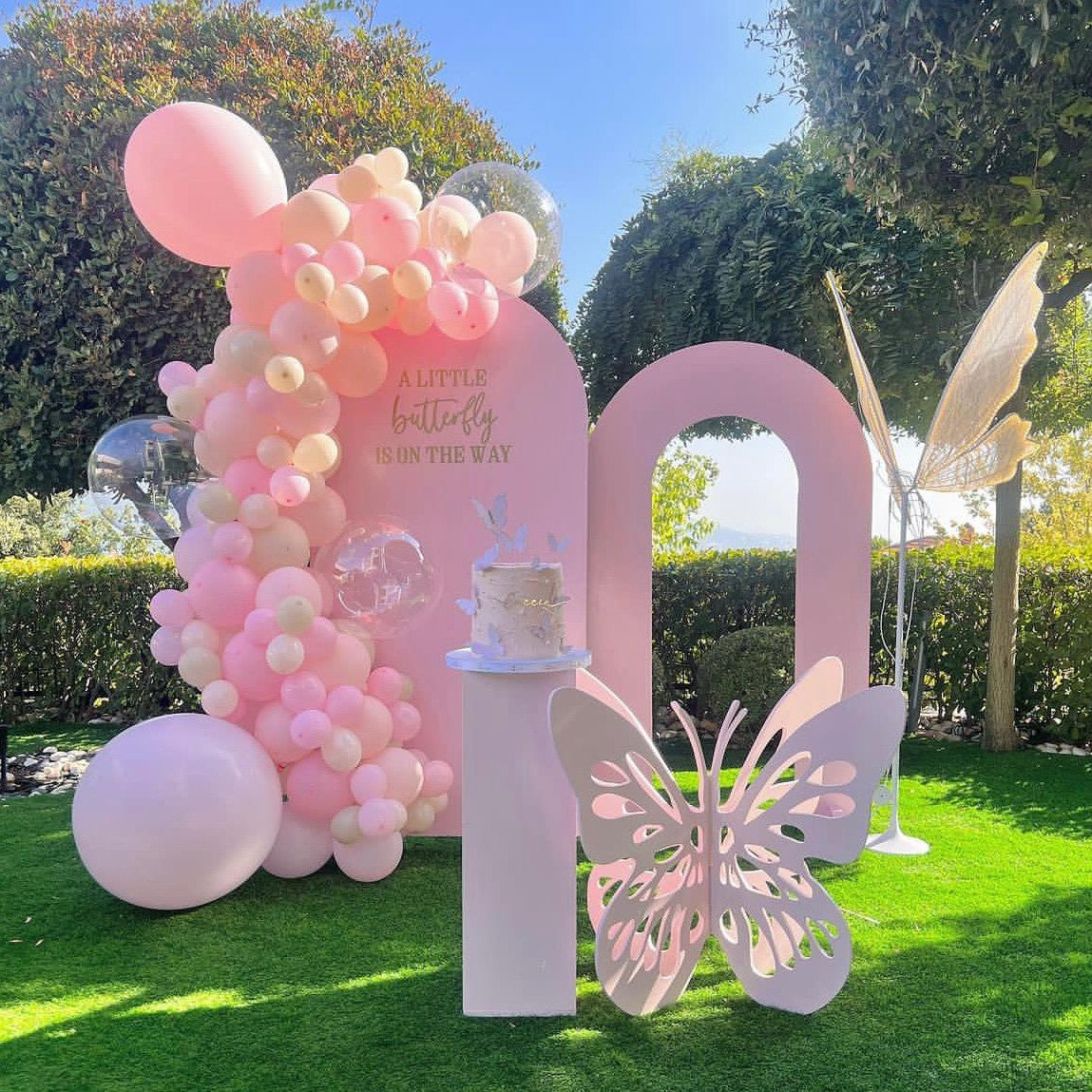 Pink balloon arch with a butterfly decoration for a birthday girl