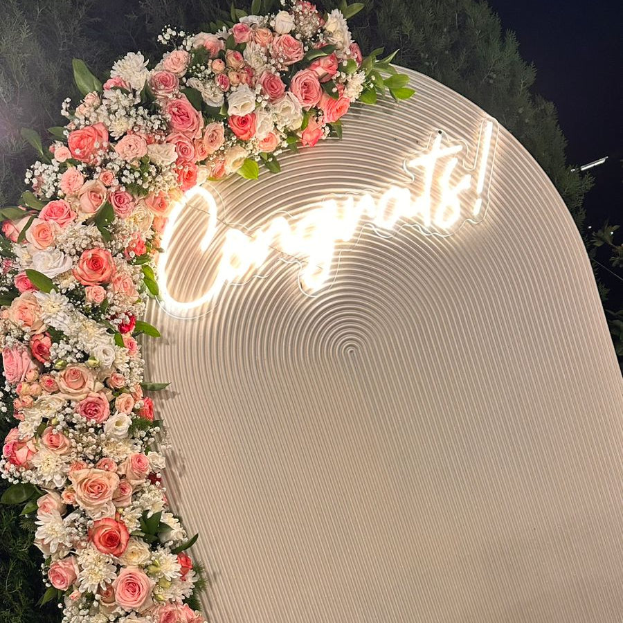 Floral arch with 'Congrats!' sign on a white archway