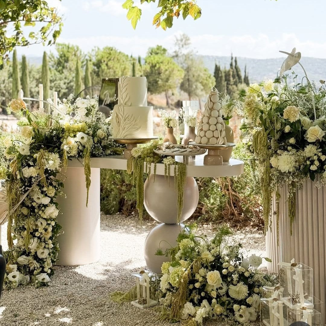 Wedding cake on a table with floral decorations outdoors