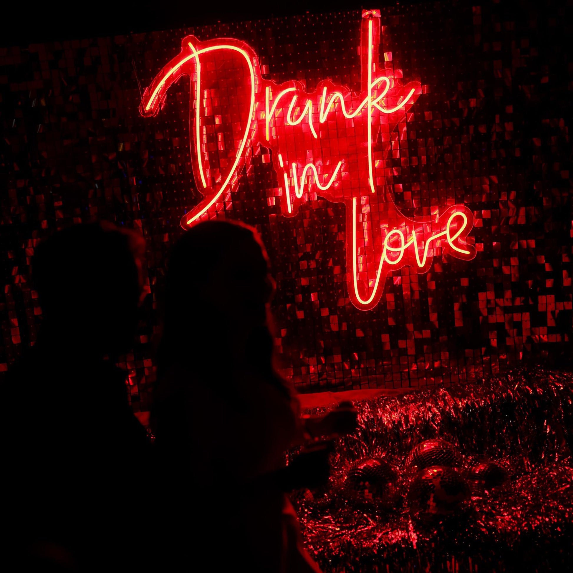 Neon sign with 'Drunk in Love' in red on a dark background