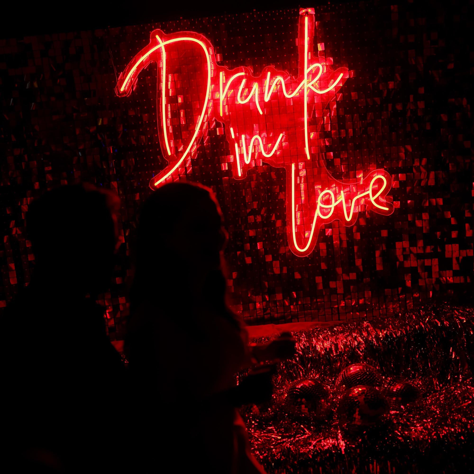 Neon sign with 'Drunk in Love' in red on a dark background