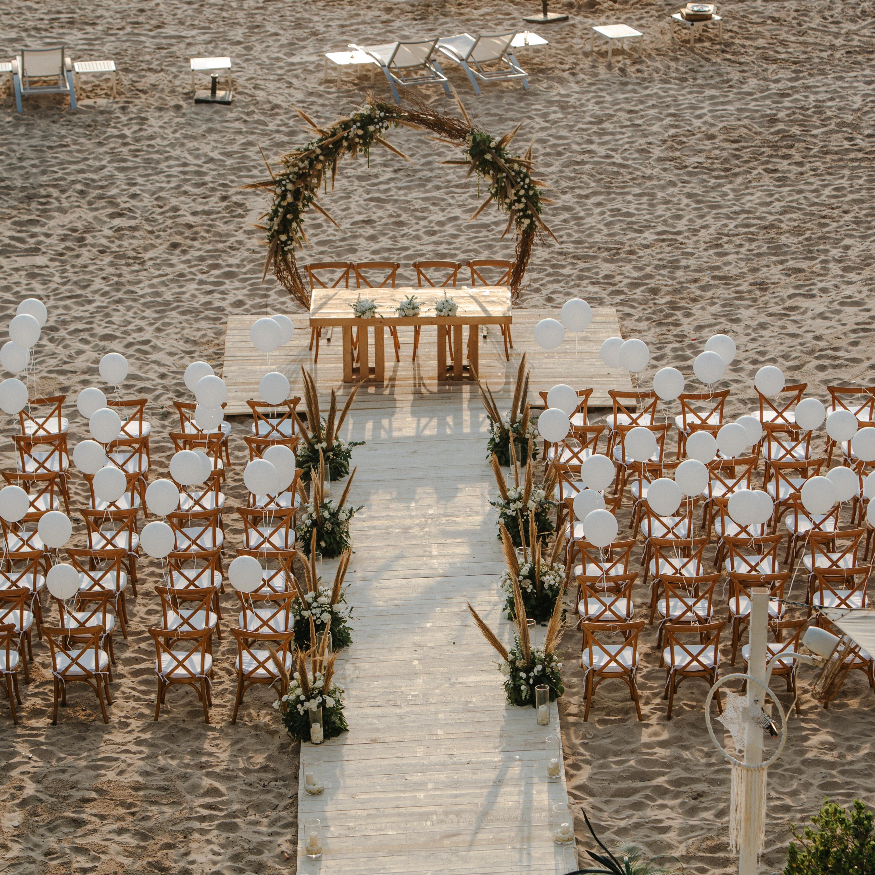 Wedding setup with chairs and decorations on a stone pathway.