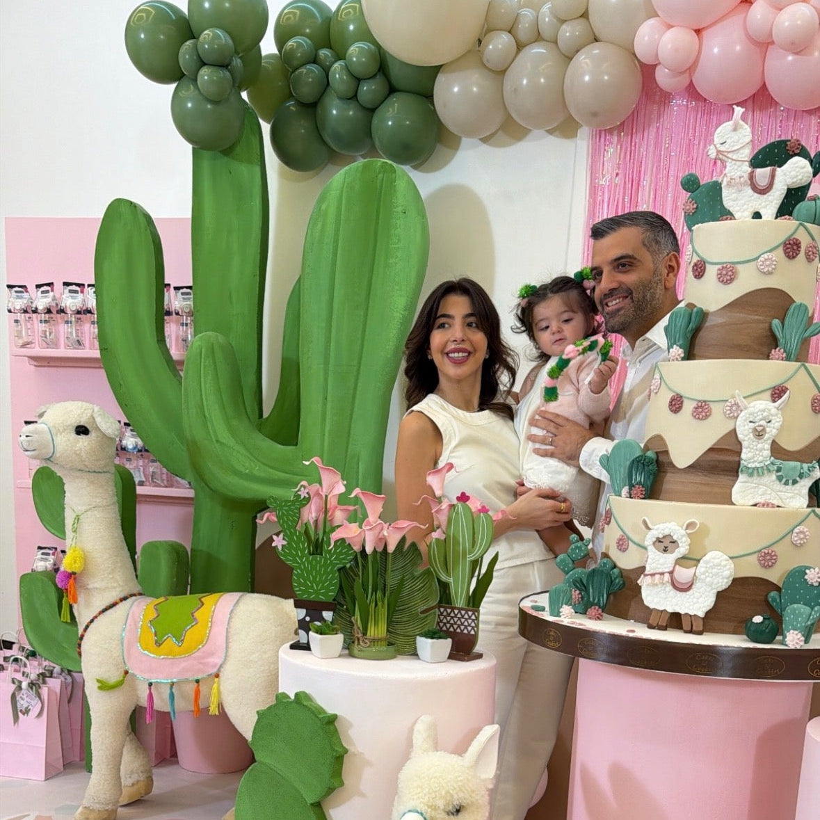 Decorative setup with cacti, llamas, and balloons for a birthday celebration.