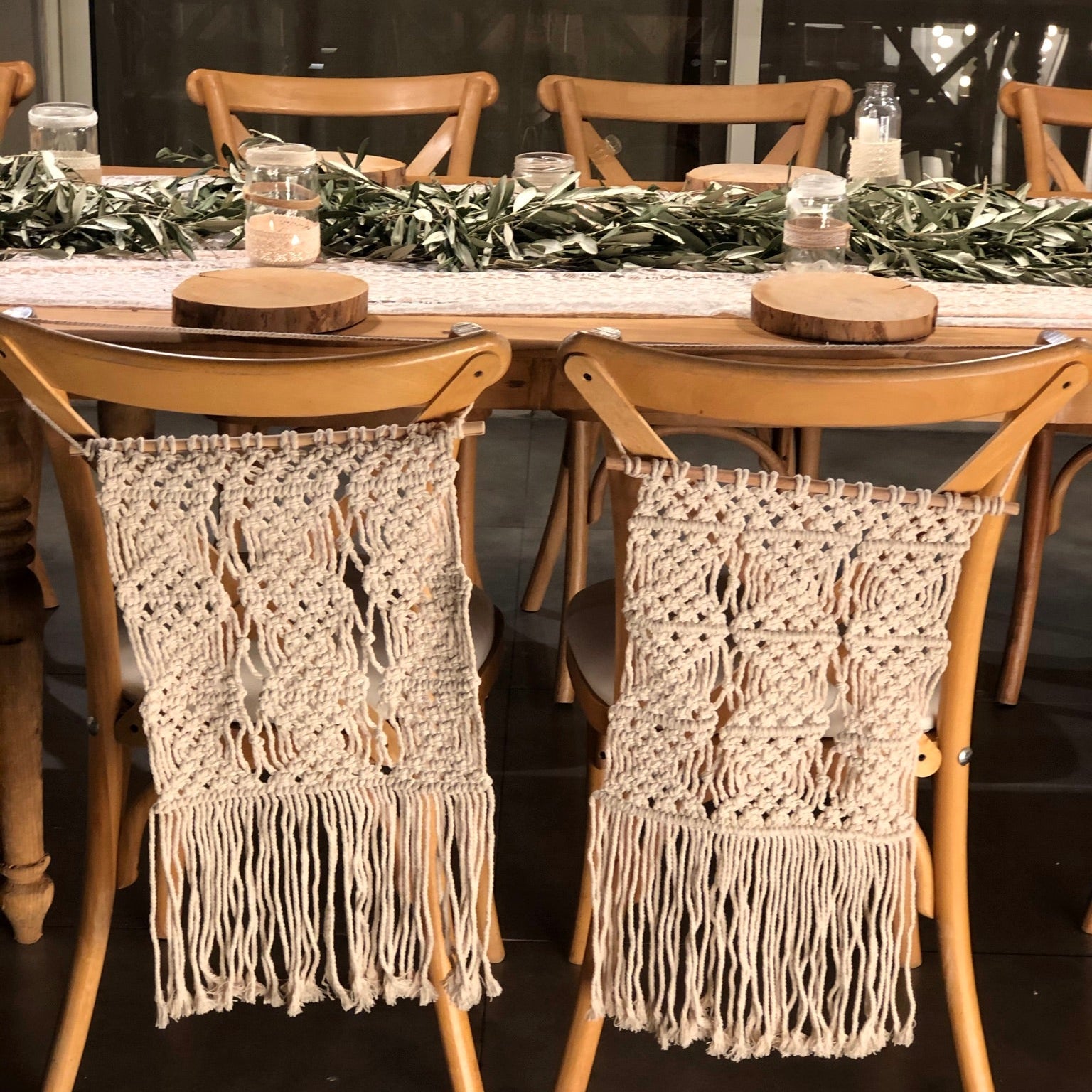 Dining table set with macrame chair covers and a decorative tablecloth.