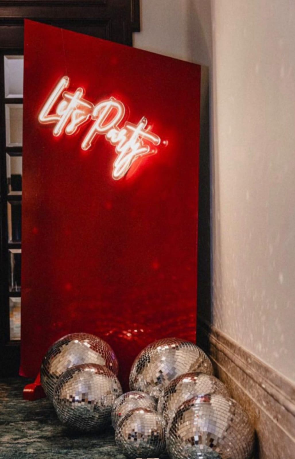 Neon sign with 'Let's Party' text on a red background