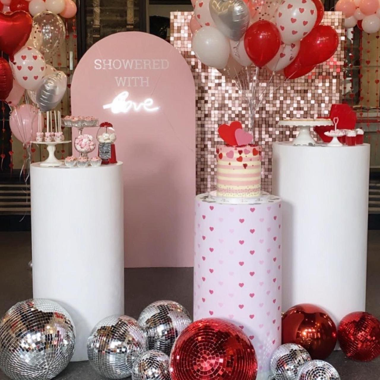 Decorative setup with balloons, cake, and 'Showered with Love' sign in a festive setting.
