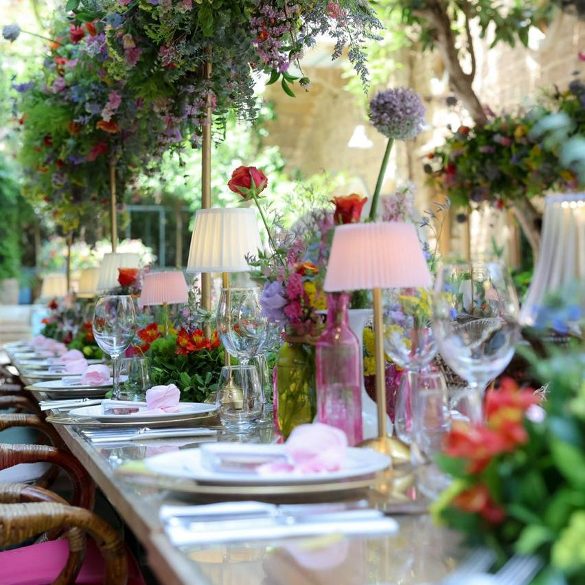 Decorative outdoor setting with floral arches and table settings.