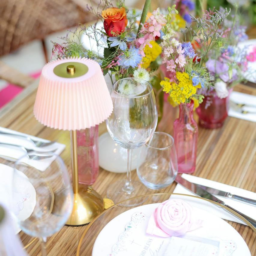 Decorative table setting with flowers, glasses, and cutlery in a restaurant for a private event like baptism.