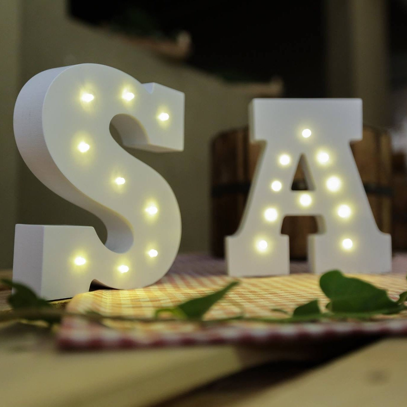 Light-up letters 'S' and 'A' on a table with a blurred background