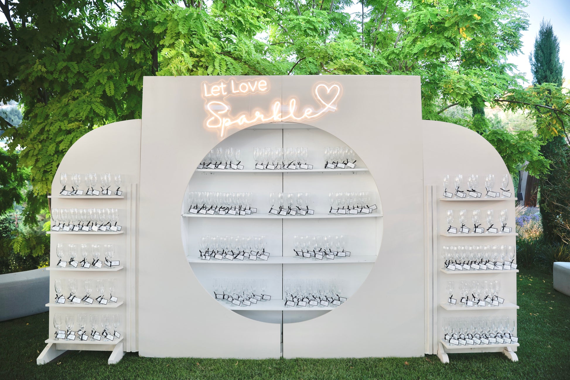 Decorative wall with 'Let Love Sparkle' sign and shelves for souvenir and weddings display