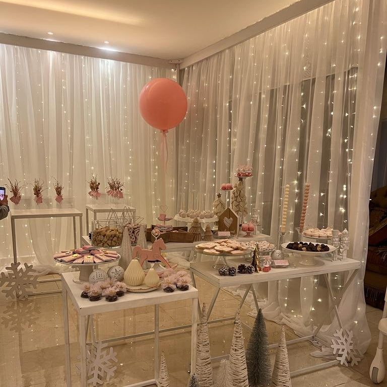 Decorated room with tables set for a celebration, balloons, and festive decorations.