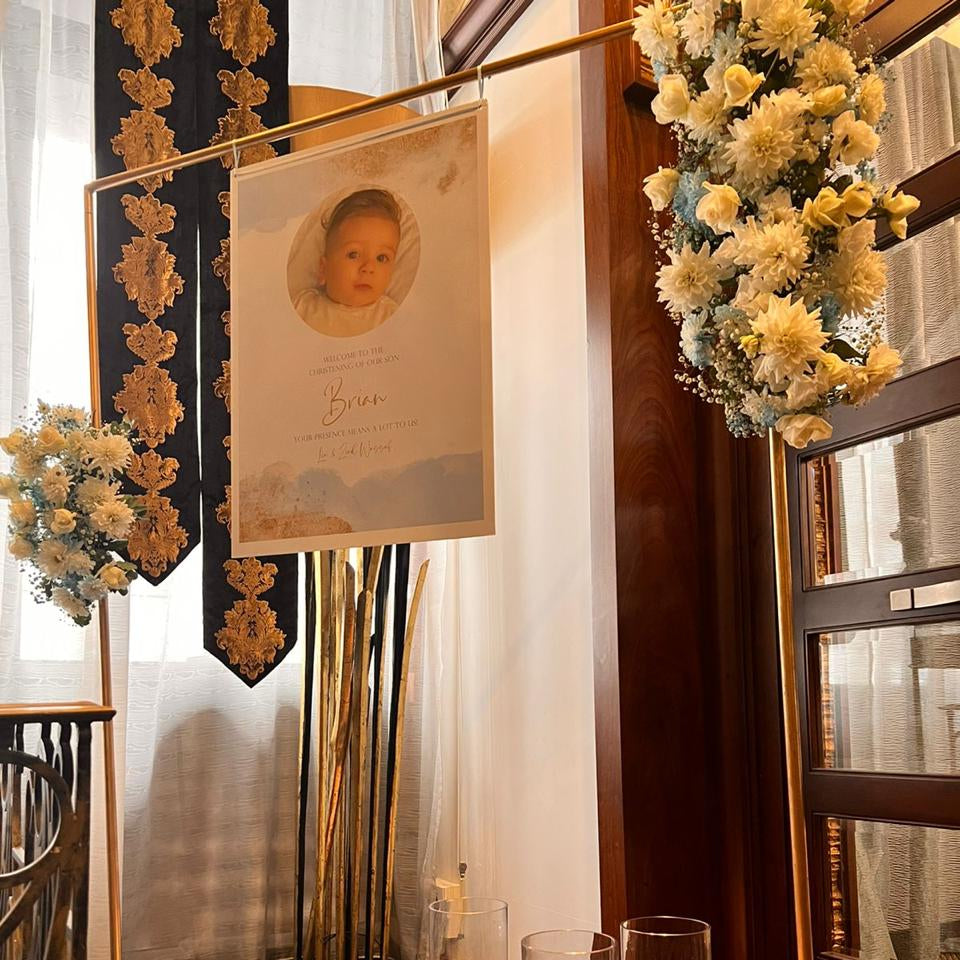 Decorative setup with candles, flowers, and a framed picture on a marble floor.
