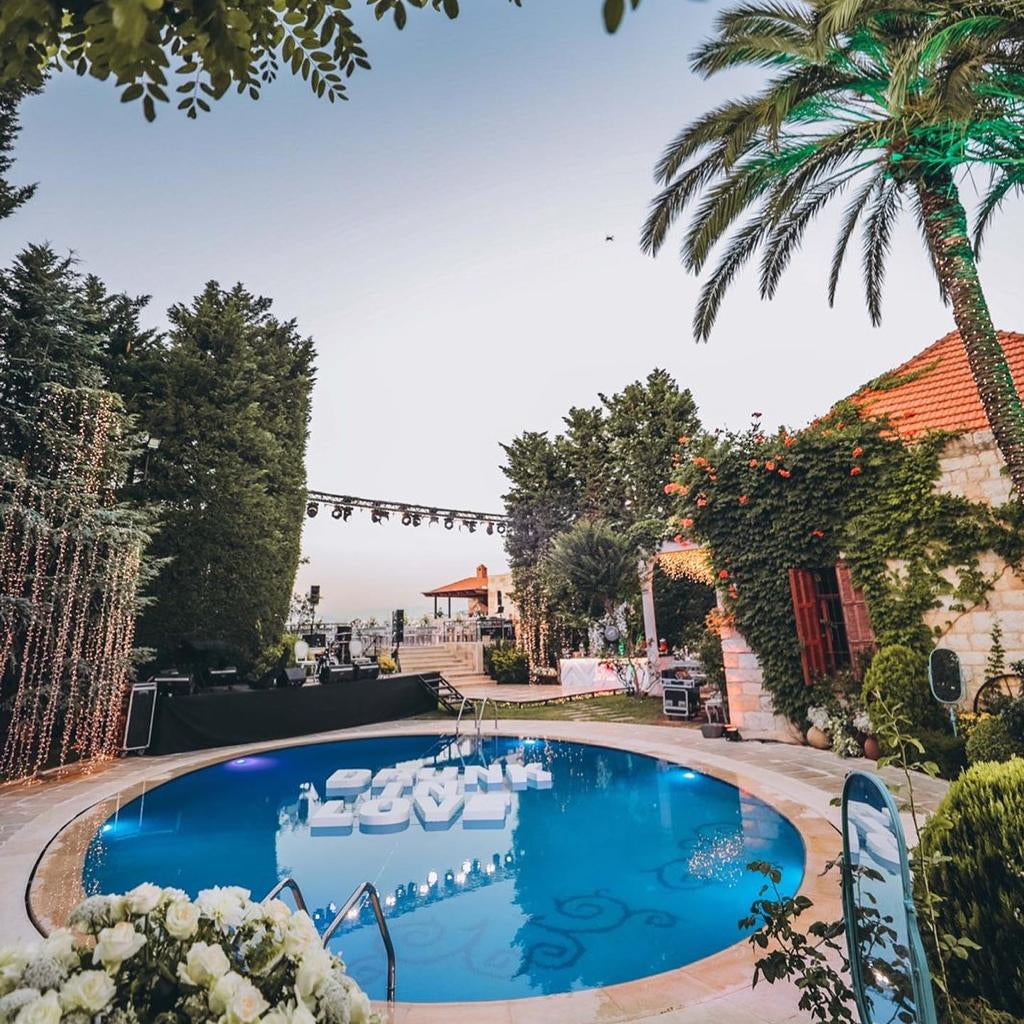 Pool area with palm trees and a clear sky