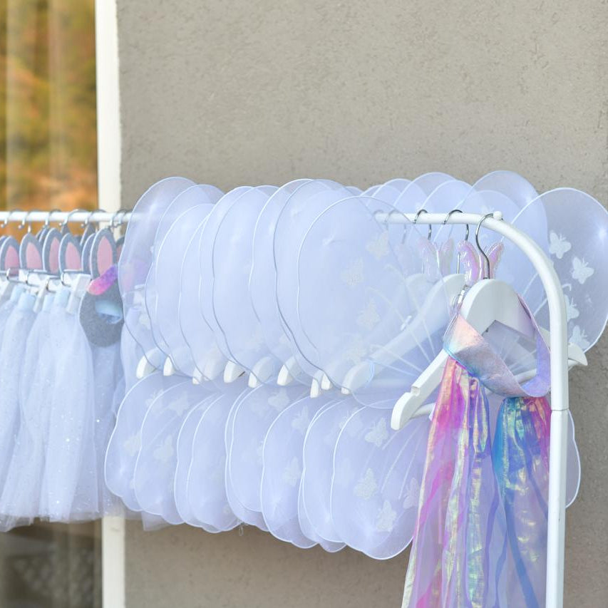 White tutus on hangers against a neutral wall