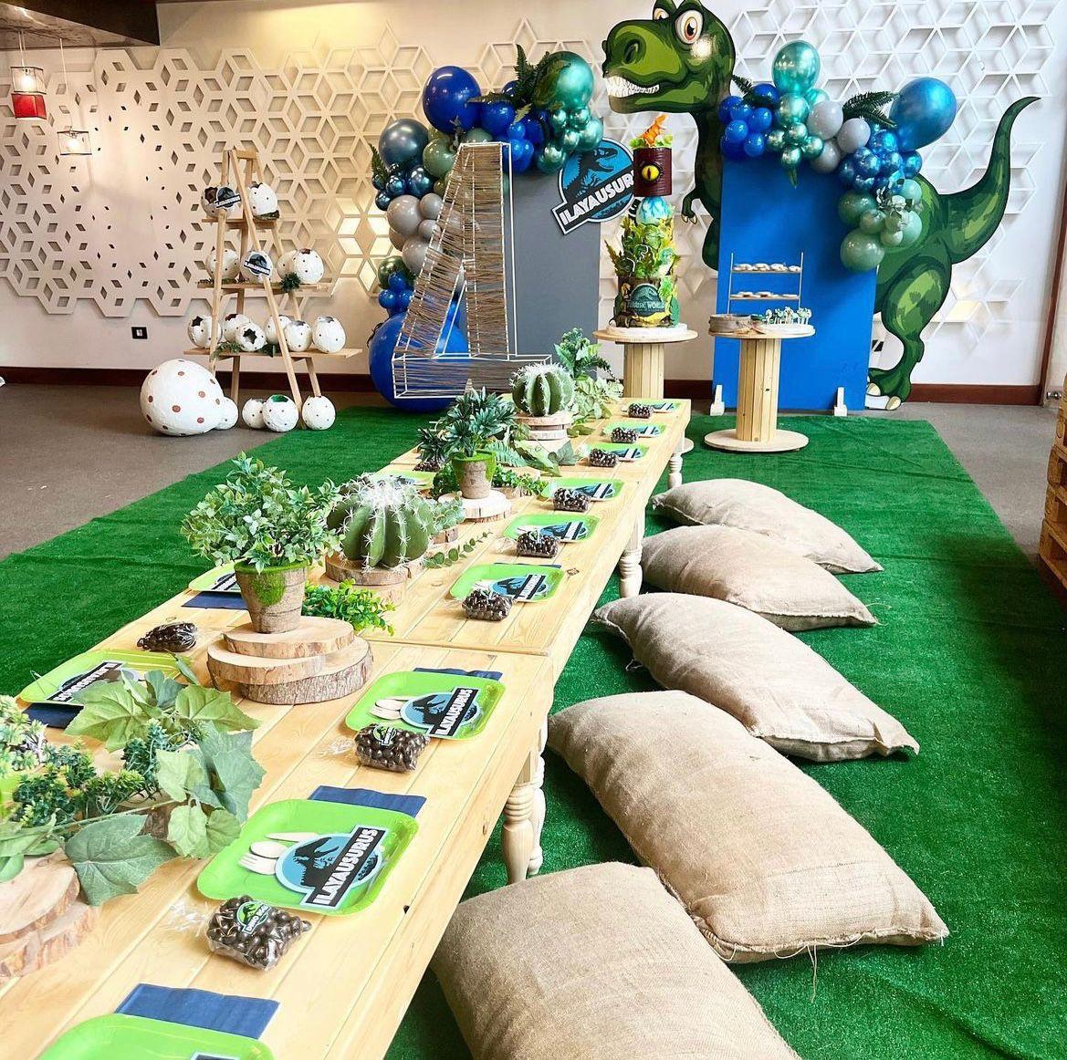 Children's party setup with dinosaur-themed decorations, balloons, and table settings.