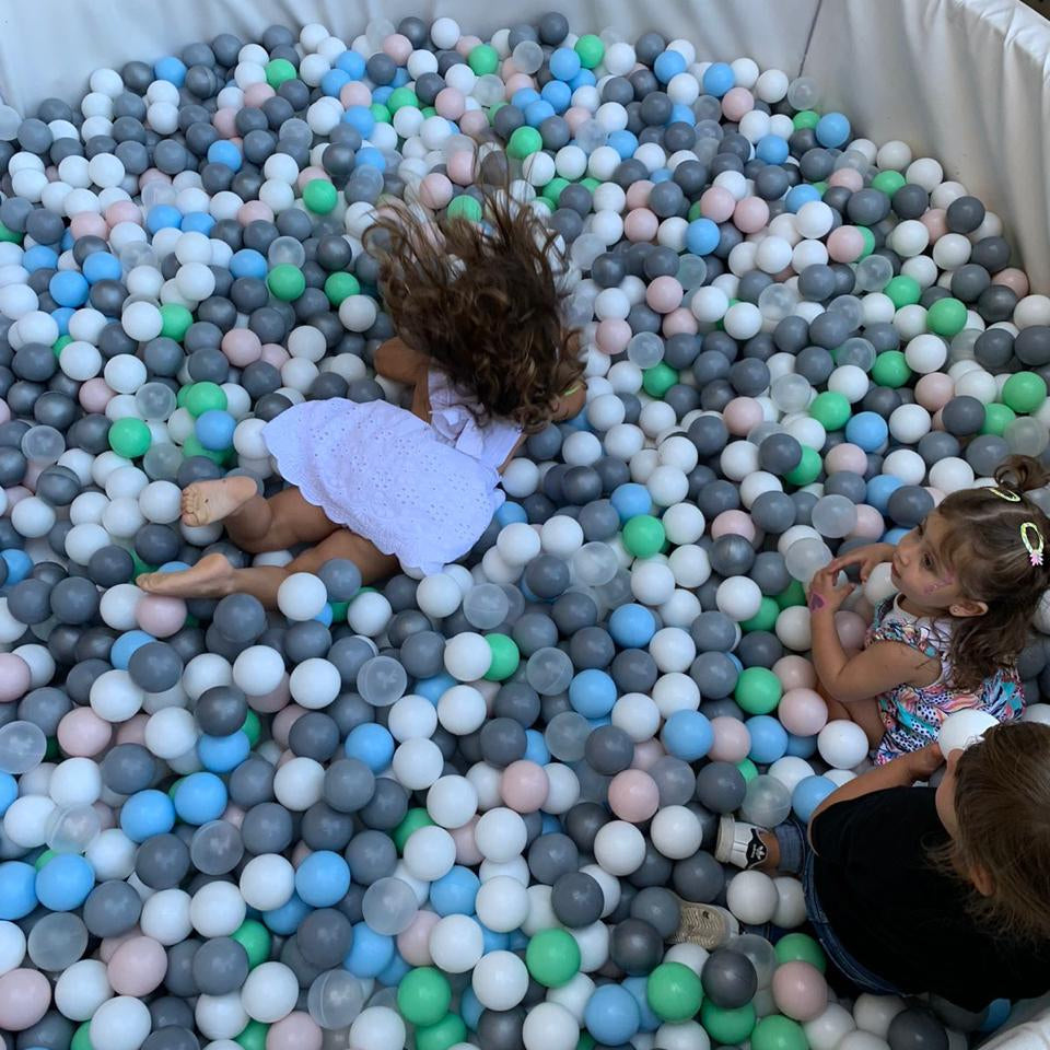 Children playing in a ball pit filled with multicolored balls.