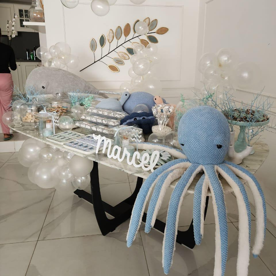 Display of trays with animal shapes on a decorative table for a newborn setup under the sea.
