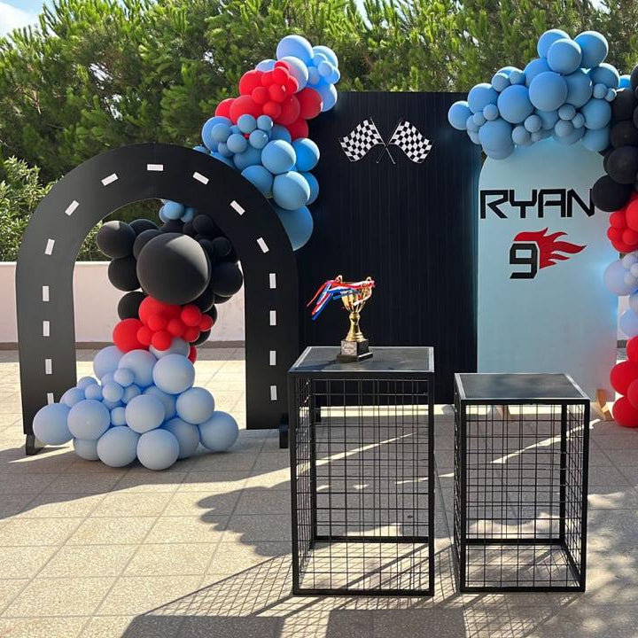Decorative setup with balloons and a 'Ryan' branded backdrop in an outdoor setting.