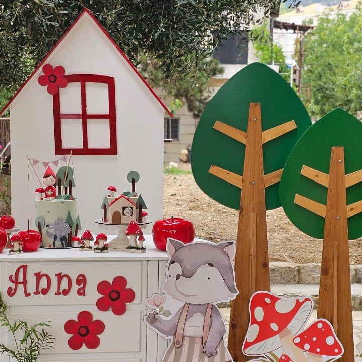 Children's playhouse with decorative elements and trees in a garden setting for a birthday party
