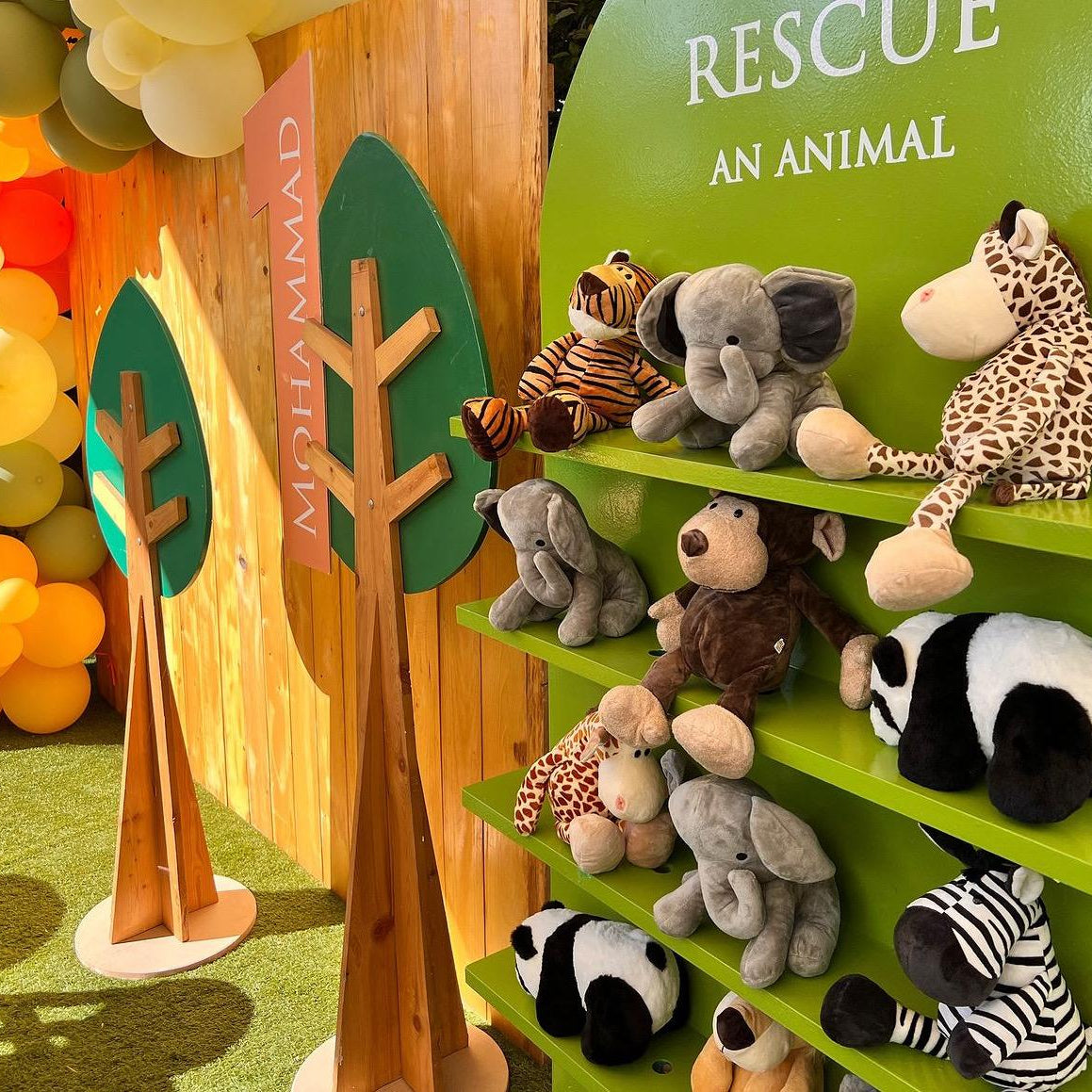Children's play area with stuffed animals on shelves and decorative trees.