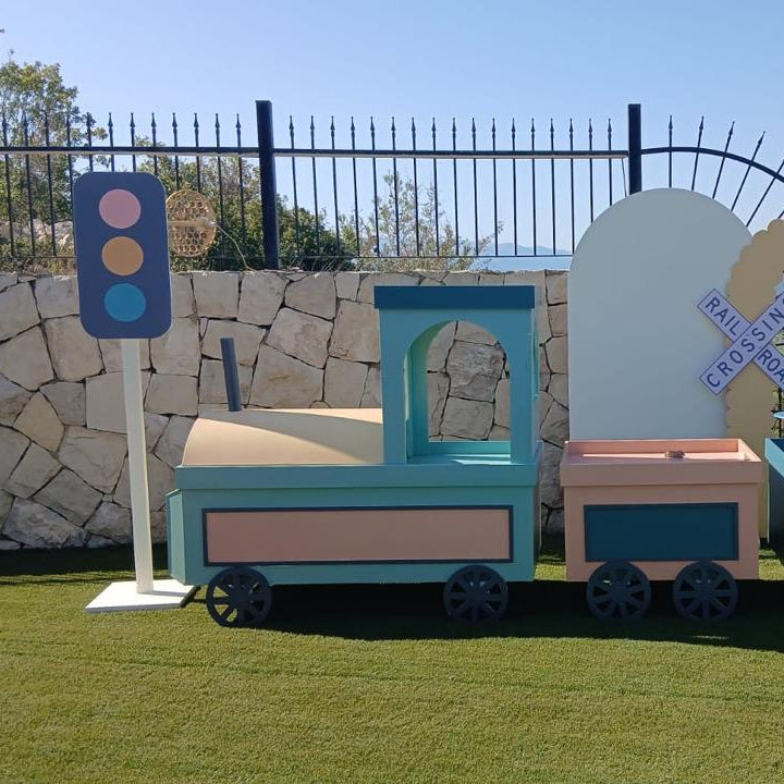 Children's toy train set with trees and traffic lights on a grassy area.
