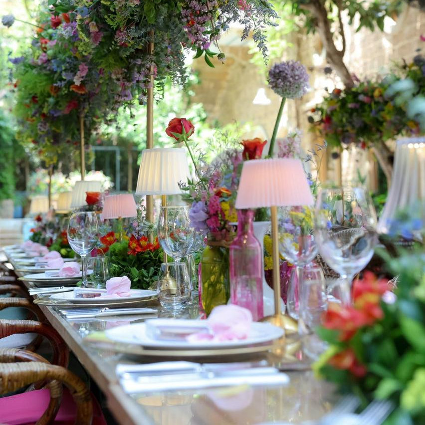 Decorative outdoor setting with floral arches and table settings.