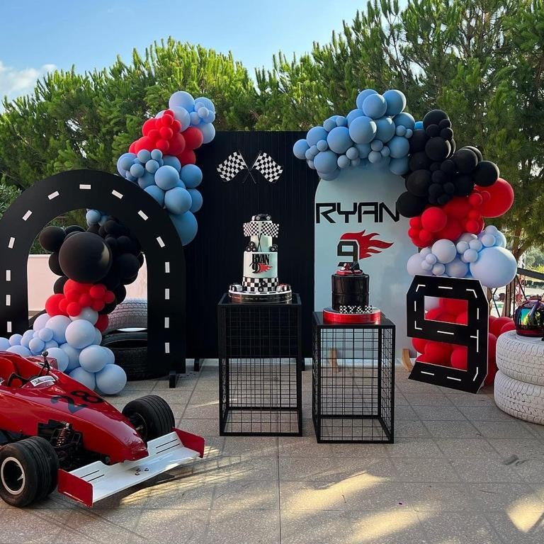Decorative setup with balloons, cake, and race car theme for a birthday party.