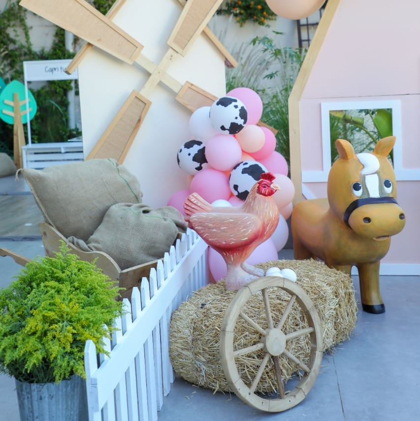 Outdoor setting with a windmill, horse, and balloons in a decorative arrangement.