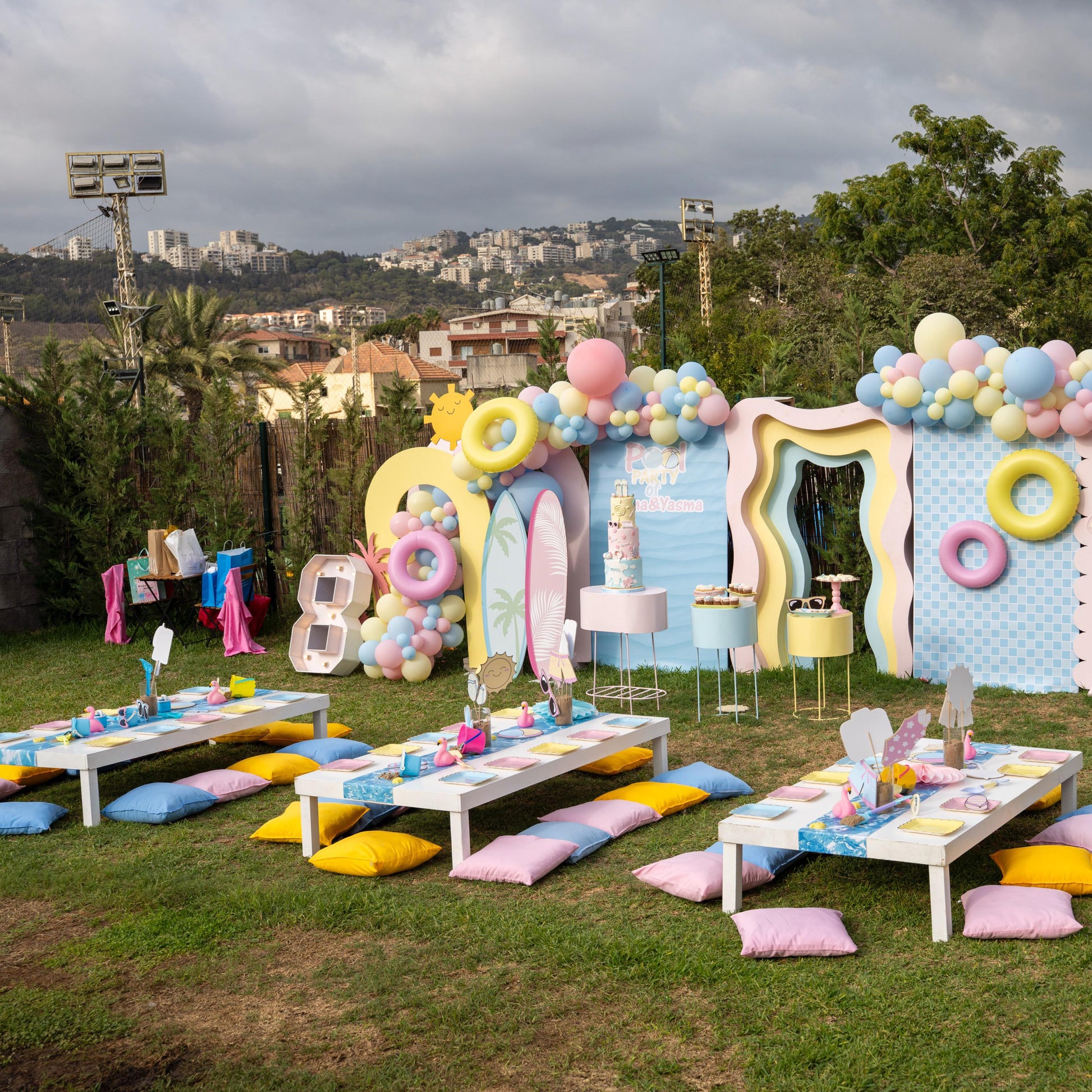 Decorative outdoor setup with balloons, props, and table settings for a celebration.